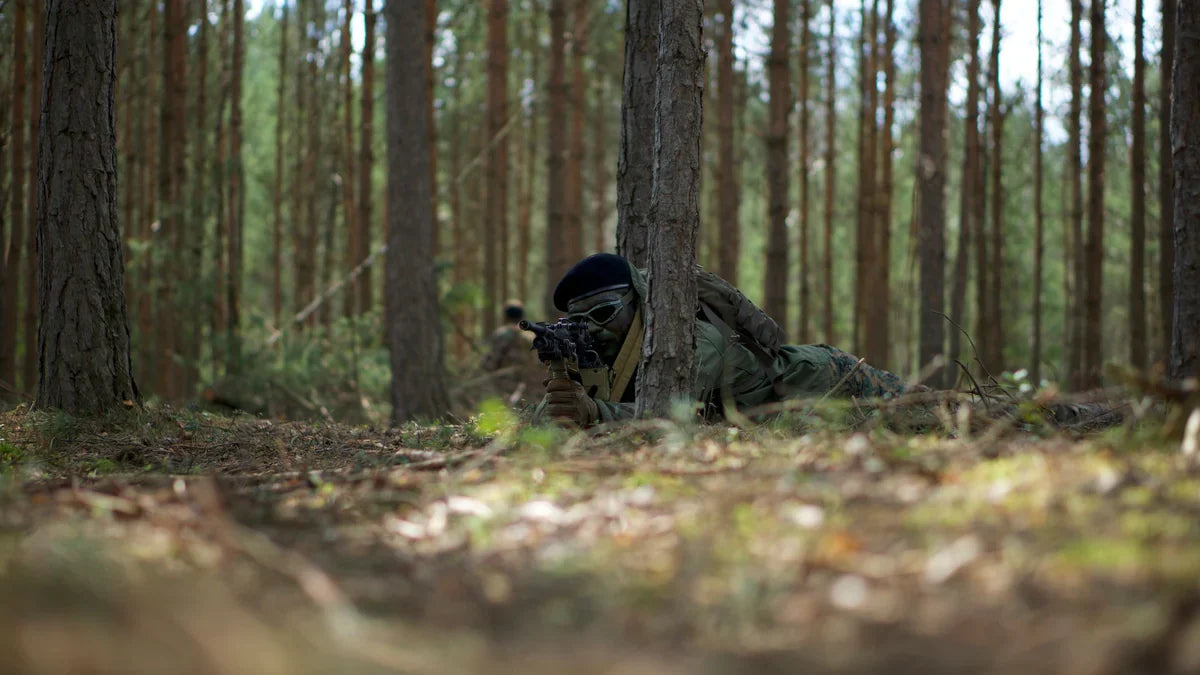 Soldat en progression furtive à couvert sur un terrain boisé