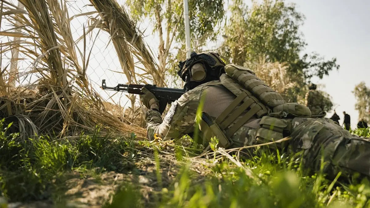 Opérateur tactique en extérieur utilisant le système des 3 couches avec veste softshell et couche thermique pour la survie en milieu froid.
